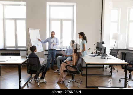 Serious diverse business colleagues listening to team leader marketing report Stock Photo