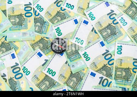 A little compass shown from above on many 100 euro money bills, making a right choice concept. High quality photo Stock Photo