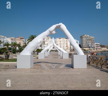 Vieste, Italy - 25 August 2023:View of Building Bridges, six pairs of giant hands, 15 meters high and joined, in the heart of Vieste on the Marina Pic Stock Photo