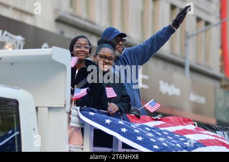 New York City, United States. 11th November, 2023. Parade marchers holding flags on a parade float during the Annual Veterans Day Parade along 5th Avenue in New York City. Credit: Ryan Rahman/Alamy Live News Stock Photo