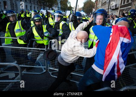 London, UK 11 November, 2023. Two people clash with the police after guarding the Cenotaph. Tommy Robinson voiced the motive to deter any Pro-Palestinian protesters that might want to march through Whitehall during Remembrance weekend. This comes after five consecutive weeks of protests to stop the war in Gaza.ÊAndy Barton/Alamy Live News Stock Photo