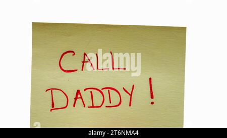 Call daddy handwriting text close up isolated on yellow paper with copy space. Stock Photo