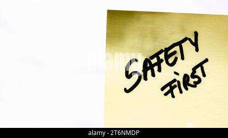 Safety first handwriting text close up isolated on yellow paper with copy space. Stock Photo