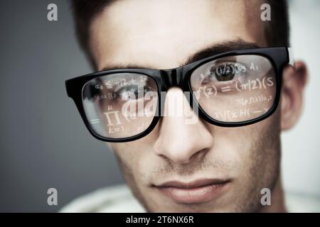 Portrait, glasses and formula with a man programmer closeup in studio on a gray background for support. Face, eyewear and software development with a Stock Photo