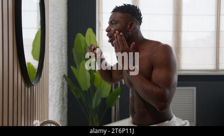 African American man brushing teeth with toothbrush feeling toothache pain hurt sensitive bleeding gums periodontitis inflammation tooth decay oral Stock Photo