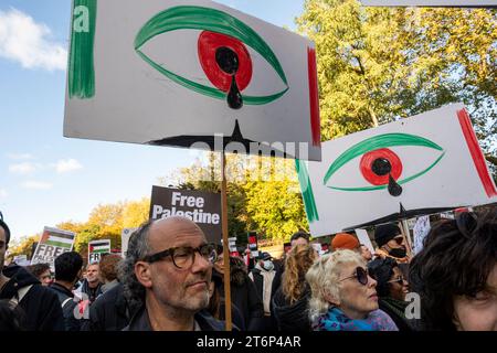 Protesters against the war on Gaza with two placards depicting eyes with tears in the Palestinian colours. London. Stock Photo