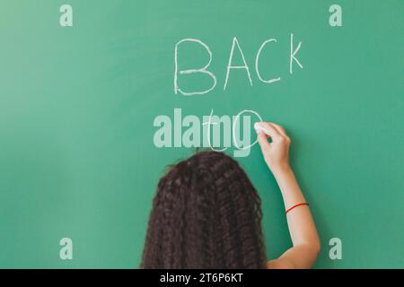 Brunette girl standing chalkboard writing Stock Photo