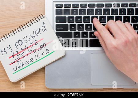 Flat lay laptop with hands notebook with password information Stock Photo