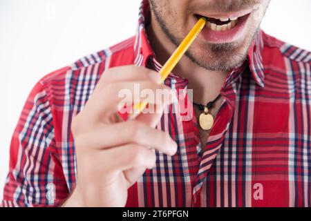 Creative moment captured as man bites pencil thoughtfully Stock Photo
