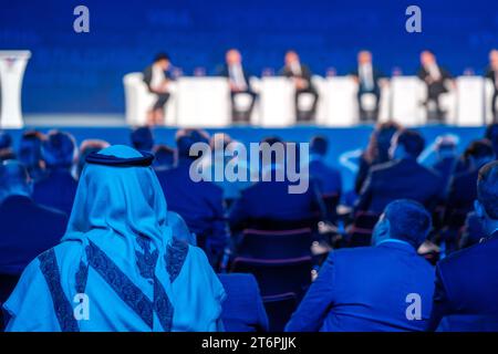 Back view of Arabian businessman attending global conference meeting in illuminated auditorium at export forum Stock Photo