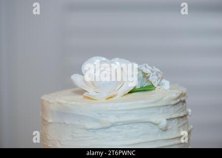 Beautiful edible white flower cake topper on white wedding cake Stock Photo
