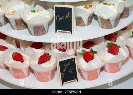 Strawberry and carrot cupcakes on cake stand with chalkboard signs Stock Photo