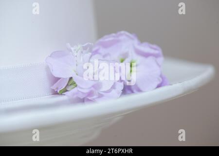 White layer wedding cake with purple flower decorations close up Stock Photo