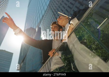 Two managers talking during break standing on terrace on background of modern office building Stock Photo