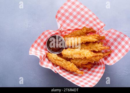 Cooked tempura shrimp in a basket with dipping sauce freshly made and ready to eat Stock Photo