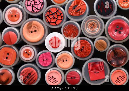 Collection of assorted red buttons in various patterns and designs  in haberdashery shop Stock Photo