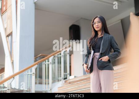 young casual businesswoman standing on staircase Stock Photo