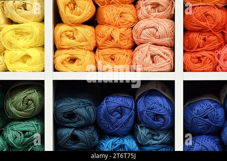 Colourful yarn balls organized in rows for knitting projects in haberdashery shop Stock Photo