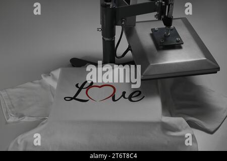 Printing logo. Heat press with t-shirt on white table Stock Photo