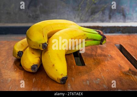 bunch of ripe yellow banana on a wooden surface. Stock Photo