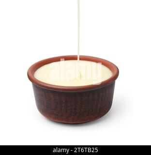 Pouring condensed milk into bowl isolated on white Stock Photo