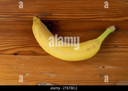 ipe yellow bananas on a wooden surface, viewed from above Stock Photo