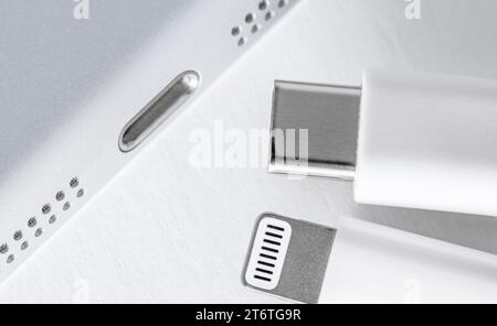 Apple Lightning to USB-C cable on the gradient white background, close up. Technology concept. Stock Photo