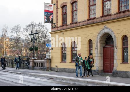 Football fans of Hammarby IF from Stockholm walk along street Kungsgatan towards Platinumcars Arena in Norrkoping to watch their team. Stock Photo