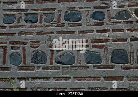 Natural pattern for backgrounds and wallpapers by decorating a red brick wall with stone blocks  attached with concrete,  Dragalevsky  Monastery Stock Photo