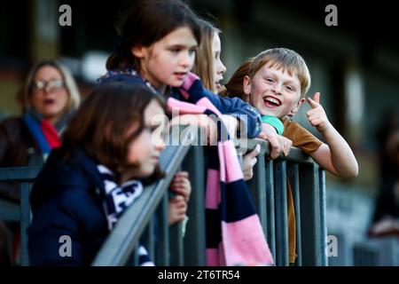 Children supporters of Dulwich Hamlet Women watch their team from railings of the main stand at Champion Hill stadium Stock Photo