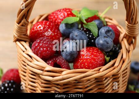 Many different fresh ripe berries in wicker basket, closeup Stock Photo