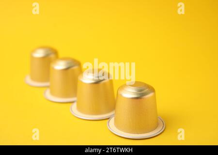 Many coffee capsules on yellow background, closeup Stock Photo