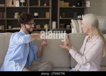 Millennial grown up son communicates with older mother using gestures Stock Photo