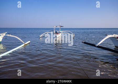 Jukung on the beach by the sea. Traditional fishing boat in the morning light. In Lovina, Bali Stock Photo