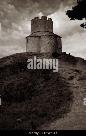 Sepia photograph.  Fortress-like church of stone rubble, the Church of Saint Nicholas, near Nin in Zadar County, North Dalmatia, Croatia.  Built on a prehistoric mound to a trefoil plan in the late 1000s or early 1100s and the only example of pre-Romanesque architecture in Dalmatia.  A central battlemented watchtower was added in the 1500s AD when the church was fortified during a 100-year conflict between the Kingdom of Croatia and the Ottoman Empire. Stock Photo