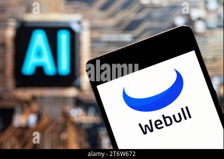 In this photo illustration, the financial trading services company Webull logo seen displayed on a smartphone with an Artificial intelligence (AI) chip and symbol in the background. (Photo by Budrul Chukrut / SOPA Images/Sipa USA) *** Strictly for editorial news purposes only *** Stock Photo