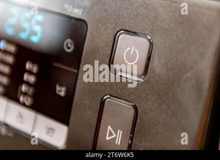 The power on and start button on a domestic appliance. Stock Photo