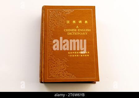 A Chinese English dictionary paper hardback isolated in white. Stock Photo