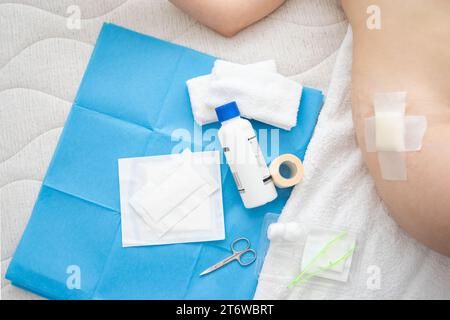 View of Body lying wounded with gauze on hip and Aid Kit utensils Background Stock Photo