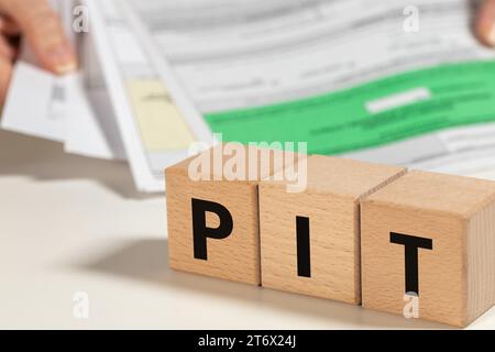 Filing annual tax return in Poland, Personal Income Tax in short PIT text on wooden blocks, person settling tax in Poland, financial concept Stock Photo