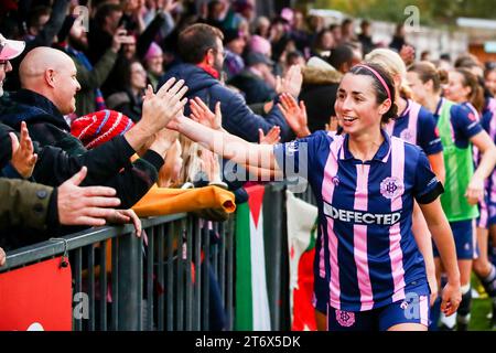 London, UK. 12th November, 2023. Phoebe Read (15 Dulwich Hamlet) with supporters of Dulwich Hamlet Women (‘The Pepper Army’) celebrating their team win at the Womens FA Cup First Round Proper game between Dulwich Hamlet and London Bees at Champion Hill. Credit: Liam Asman/Alamy Live News Stock Photo