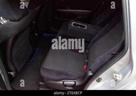 Close-up on rear seats with velours fabric upholstery in the interior of an old Korean car in gray after dry cleaning. Auto service industry. Stock Photo