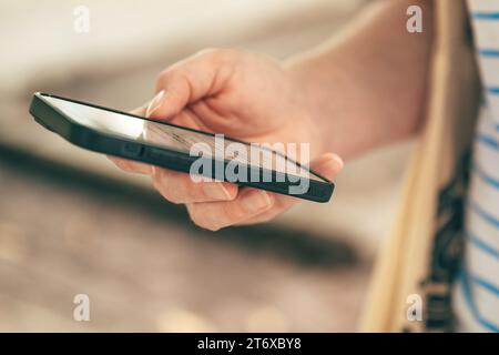 Woman using mobile phone out on the street, selective focus Stock Photo