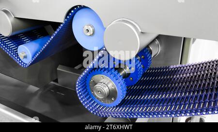 Gear chain drive shaft in conveyor belt is on production line. Timing chain of car, tensioners in engine. Industrial roller chain, technology. Team wo Stock Photo