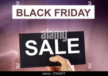 Symbol image Black Friday: BLACK FRIDAY lettering and a sign with the word SALE against an abstract background (composing) Stock Photo