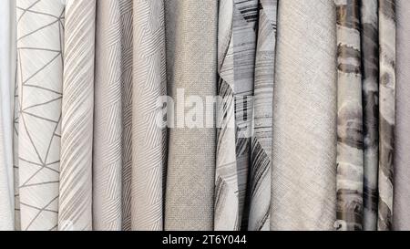 Mix colorful hanging vertical stripe textile, fabrics, cloths on the rack. Texture of multicolored fabrics close up. Stock Photo