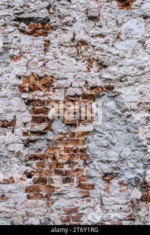 Brick wall with crumbling plaster on old building. Stock Photo