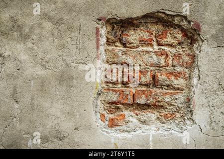 Brick wall with crumbling plaster on old building. Stock Photo