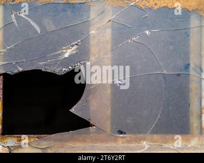 A background showing an old, broken window pane. Texture of old dirty glass, rusty frame. Stock Photo