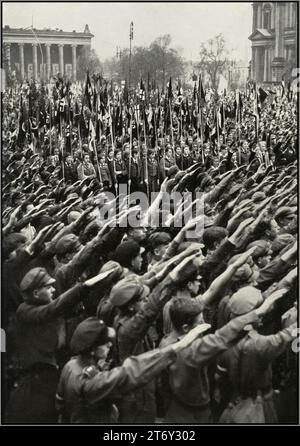1930s Nazi Germany youth rally in the Pleasure Garden Berlin, with swastika flag carrying BDM League of German Girls and HitlerJugend Hitler Youth giving the Nazi Party Heil Hitler salute to Fuhrer Adolf Hitler. 'Germany Awakes' The rise of Nazism in Germany 1930s Stock Photo